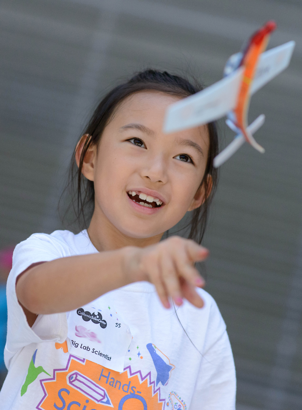 Girl throwing plane, while attending Hands-On Science Camp