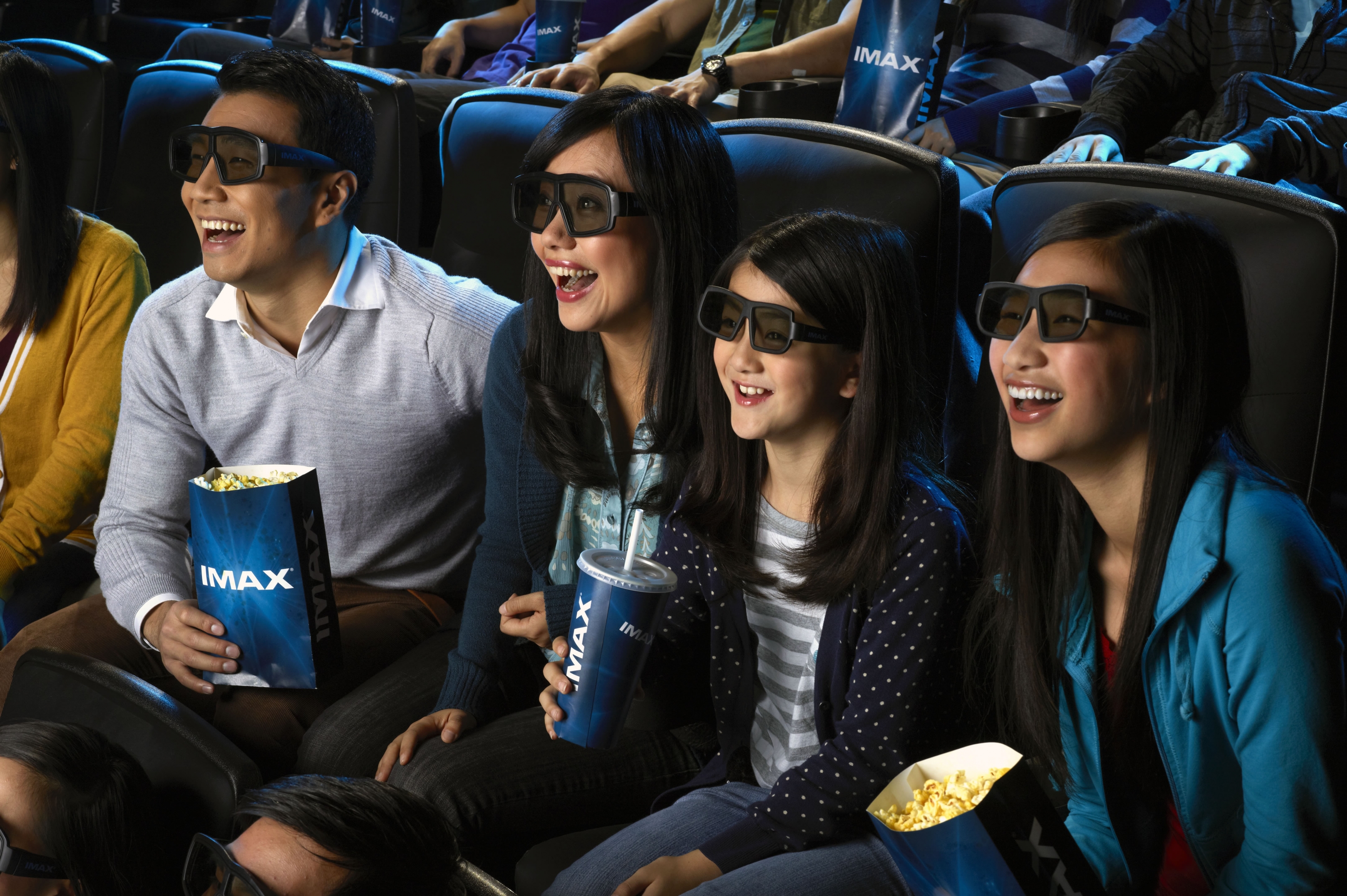A family wearing 3D glasses and watching a film in the IMAX theater