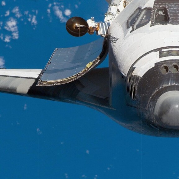 Endeavour in orbit with its payload bay doors open and Earth in the background