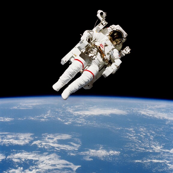 An astronaut in a spacesuit floats untethered above Earth.