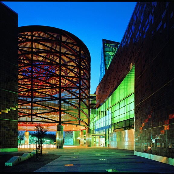 Empty Lorsch Family Pavilion, California Science Center front entrance, dramatically lit at night