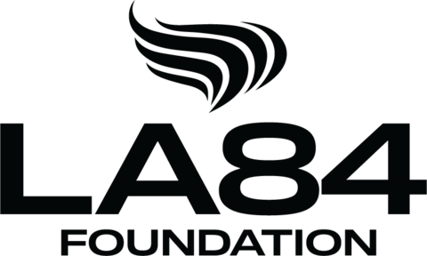 LA84 Foundation written in black text on white background with black Olympic flame shape in black above