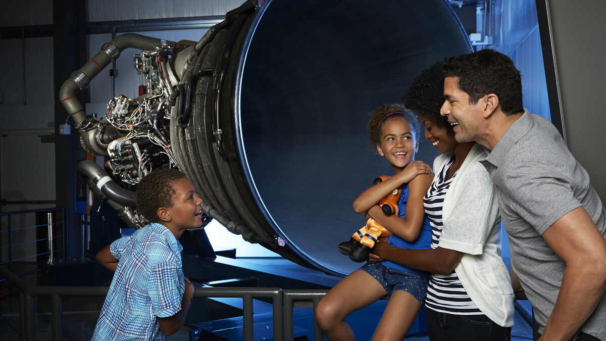 Family sitting in front of Endeavour's engine