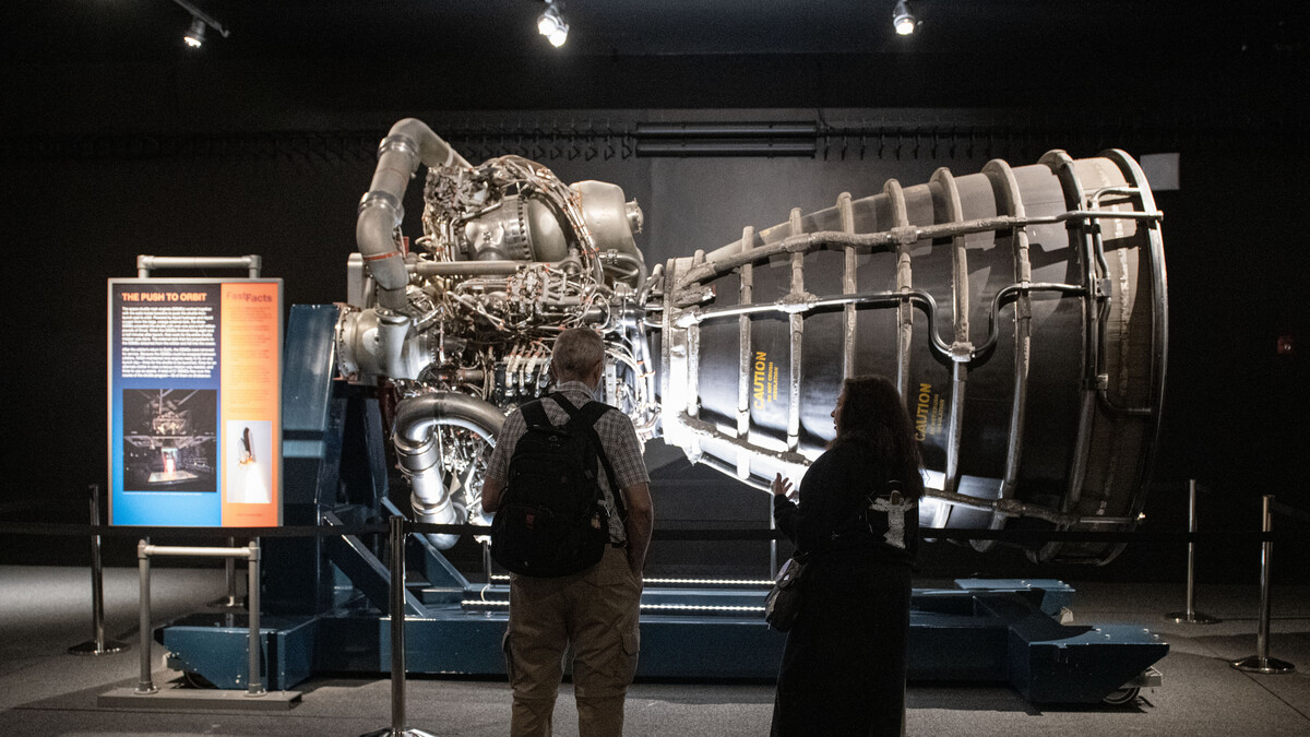 Visitors silhouetted as they observe the space shuttle main engine.