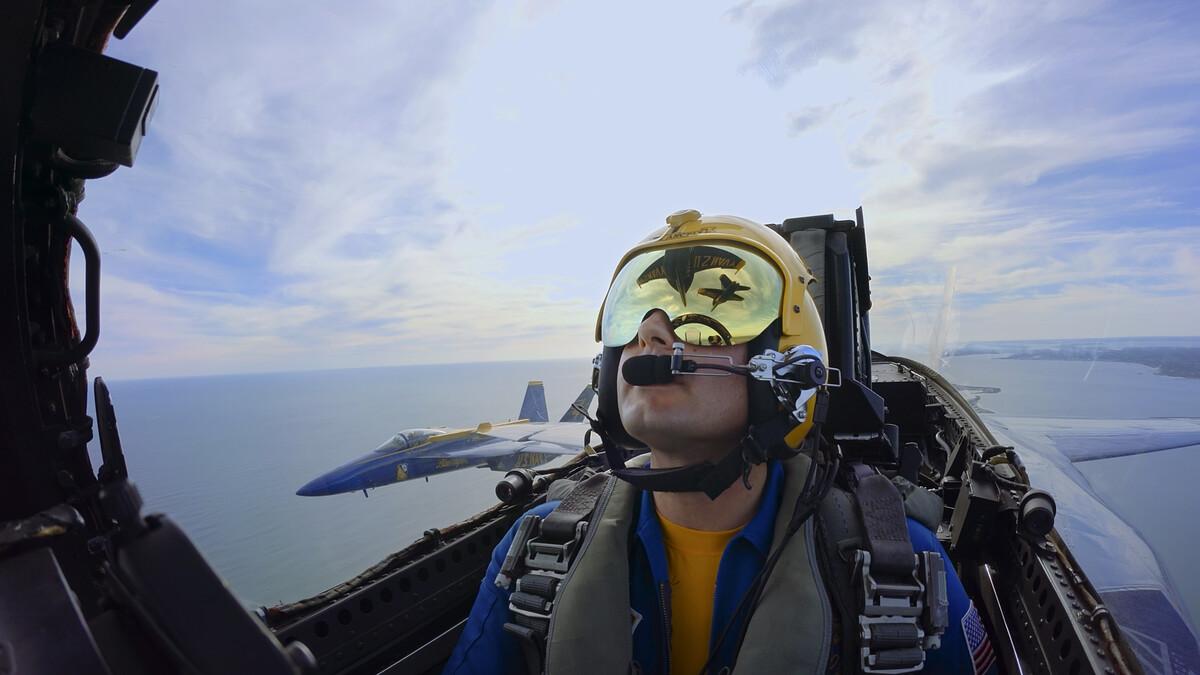 A Blue Angels pilot is seen inside his plane while flying next to another Blue Angel plane.