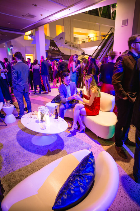 Event guests enjoying cocktails on futuristic white lounge furniture on Disney Court