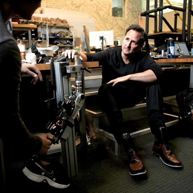 Dr. Herr sits next to a prosthetic.