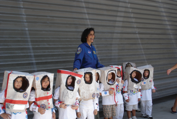 Young kids dressed as astronauts standing in front of NASA astronaut